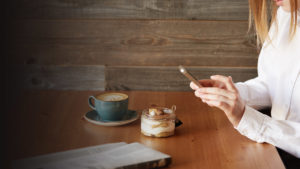 woman at coffee shop using mobile banking