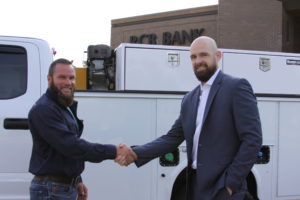 business owner Jesse Jones shaking hands with market president Garrett Chaney