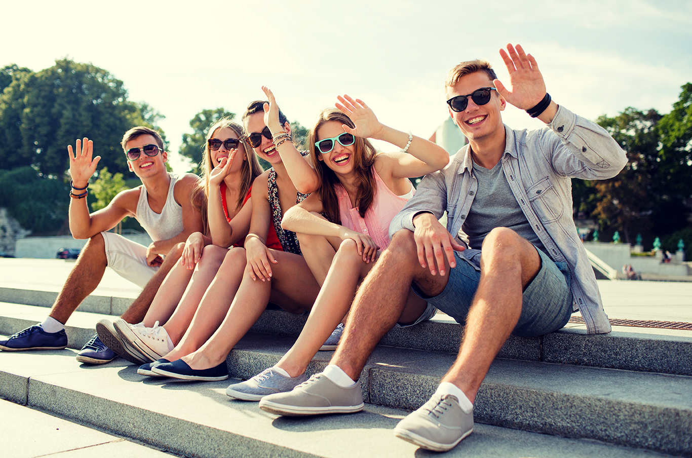 young adults smiling and waving