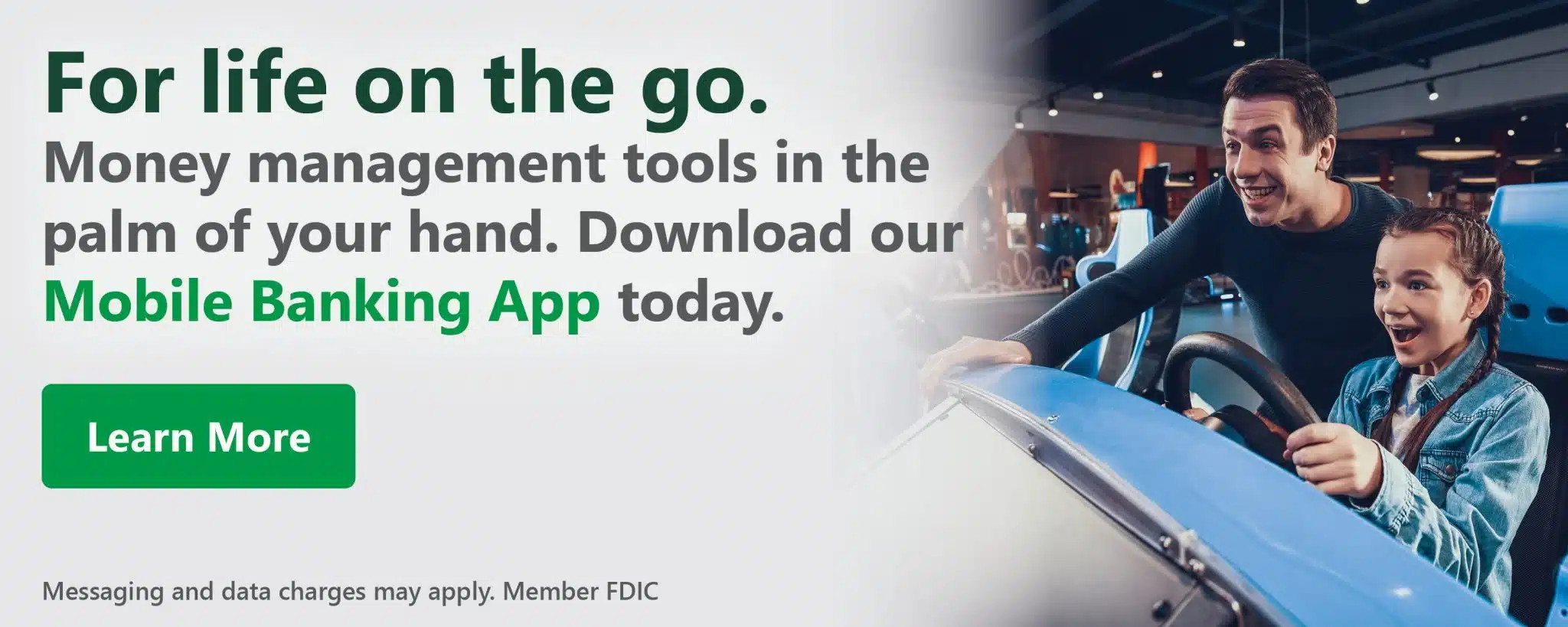 Father and daughter enjoy a ride in a blue car at an arcade. Text promotes a mobile banking app with phrases like "For life on the go." Learn More button included.