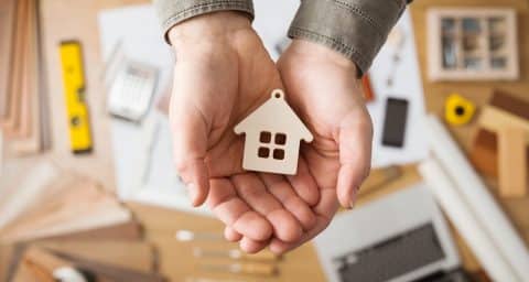 Hands hold mini house